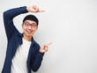 © Thanasak - Young man wearing glasses gesture point finger at copy space portrait white background