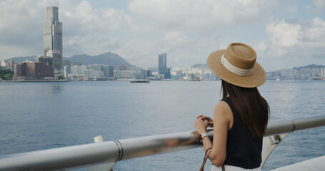 Poster - Woman look at the Hong Kong city at sunset time