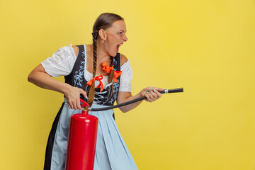 Wall Mural - Comic portrait of beautiful Oktoberfest woman, waitress wearing a traditional Bavarian or german dirndl isolated on yellow studio background.