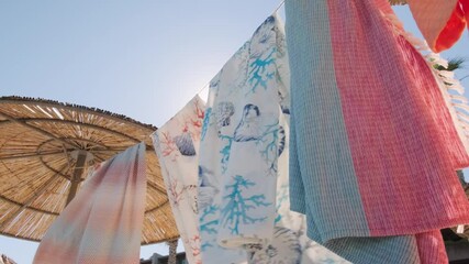 Poster - A vibrant hung fabric at the beach under a bright sunny day in 4K