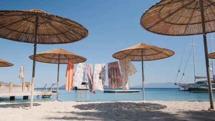 Wall Mural - A vibrant hung fabric at the beach under a bright sunny day in 4K