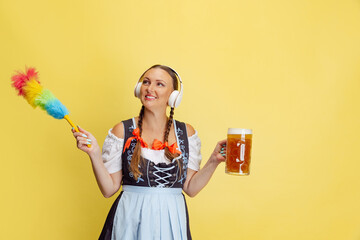 Wall Mural - Comic portrait of beautiful Oktoberfest woman, waitress wearing a traditional Bavarian or german dirndl isolated on yellow studio background.