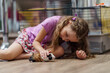 happy little girl is sitting on floor and stroking fluffy guinea pig with her hand. child takes care animal, feeds it and plays with it. Pet care. Training in responsibility and care an animal.