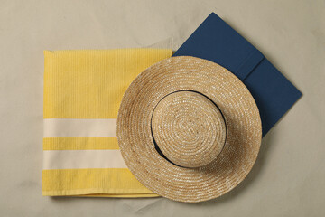 Wall Mural - Beach towel, hat and book on sand, top view