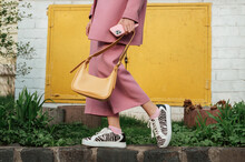 Street Fashion Elements: Woman Wearing Trendy Outfit With Pink Suit, Zebra Print Sneakers, Holding Yellow Faux Leather Handbag. Copy, Empty Space For Text