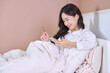 woman smile and use phone on bed