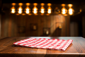 Napkin and board for pizza on wooden desk. Stack of colorful dish towels on white wooden table background top view mock up. Selective focus.