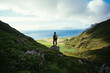 © BublikHaus - Man with hiking backpack stand on top of mountain, overlook epic views and nordic scandinavian landscape. Modern adventure traveller concept. Young people spend quality time in nature