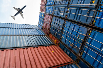 Freight airplane flying above overseas shipping container . Logistics supply chain management and international goods export concept .