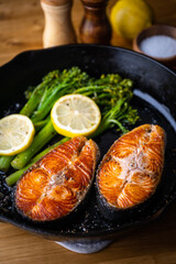 Wall Mural - roasted salmon fillet steak with broccolini and lemon slice on iron skillet pan