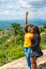 two young female african friends standing together outdoor on a hike through nature, feeling excited and happy