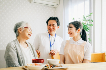 Poster - 高齢者と話す男女のスタッフ
