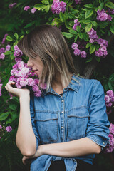 Sticker - young woman near bush of purple flowers in a garden