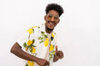 A young Cuban man with a white and green flower shirt, glasses, smiling and dancing on a white background, copy space and paste