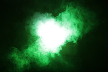 Poster - Artificial magic smoke in green light on black background