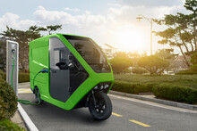 Concept Of Delivery Electric Tricycle Scooter With Charging Station On City Street