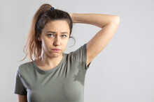 Young woman with her arm raised with her armpits sweat
