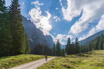 Wall Mural - beautiful active senior woman with electric mountainbike in the spectacular Mountains of Raintal Valley, a side valley of Lechtal, Tyrol, Austria