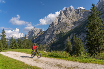 Wall Mural - beautiful active senior woman with electric mountainbike in the spectacular Mountains of Raintal Valley, a side valley of Lechtal, Tyrol, Austria