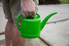 Man Holding Small Green Watering Can