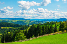 Pastures Of Young Green Grass On The Slopes Of The Mountains Against The Backdrop Of A Beautiful Blue Sky. High Quality Photo