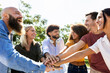 © Xavier Lorenzo - Group of united multiracial people stacking hands together - Cooperation, collaboration, community and unity concept with multiethnic young college students celebrating together on campus university