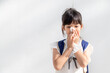 Asian child girl sick with sneezing on the nose and cold cough on tissue paper because weak or virus and bacteria from dust weather