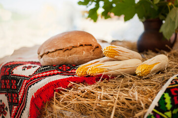 still life with corn and hay bale with towel, harvest and hospitality holiday concept