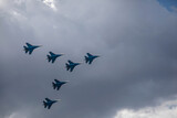 Fototapeta Na sufit - Combat aircraft are flying against the background of the sky. Cloudy sky. Beautiful fighters.
