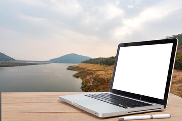 Wall Mural - Desk Laptop with blank screen on beautiful nature view blur background, copy space