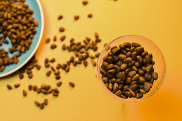 pine nuts scattered on a plate and in a transparent glass on a yellow background