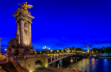 Fototapete - Pont Alexandre III (Alexander the third bridge) over river Seine in Paris, France.  Night cityscape of Paris. Architecture and landmarks of Paris.