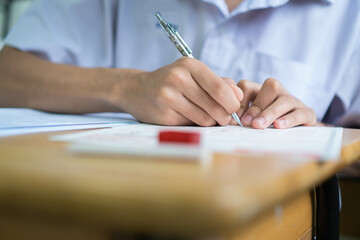 Wall Mural - Writing test in exam Asian students concentrate in high school, serious taking final examination desk at classroom with Thai student uniform. Back to school for evaluation after COVID-19 pandemic