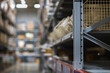 A modern warehouse with goods on folding metal shelves. Background blur, focusing with a small depth of field.