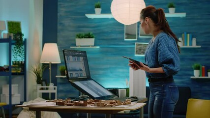 Poster - Woman architect analyzing building model on tablet and computer for construction development. Engineer using technology to design blueprint plan for architectural project. Modern architecture