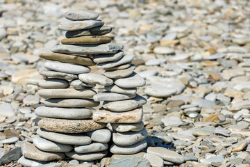 Poster - pyramid of sea stones on the beach in summer