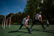 © Михаил Решетников - Caucasian man and two boys doing exercises outdoors. Father and sons train on the sports ground