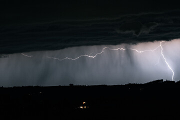 Wall Mural - horizontal and vertical lightning bolts pierce the sky above the mountains of the alps in austria