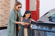 canvas print picture - Mother and daughter charging battery of electric car before driving to school