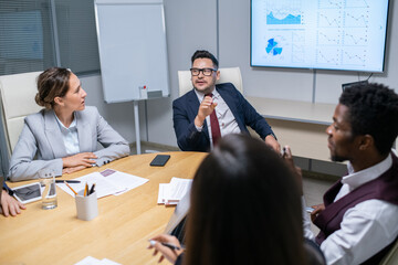 Poster - Mature business coach talking to young managers at seminar or training
