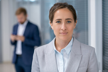 Aufkleber - Young confident female business leader in grey formalwear standing against her colleague