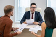 © pressmaster - Confident mature businessman with paper discussing financial points or data with his two subordinates