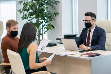 Poster - Group of economists in protective masks discussing financial documents at meeting