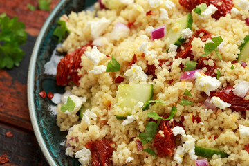 Wall Mural - Couscous salad with sun dried tomatoes, cucumber, red onion and feta cheese. healthy food.