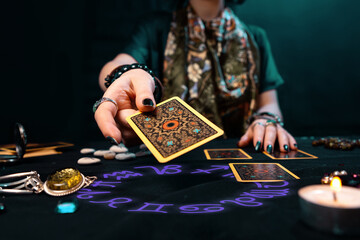 fortune-telling on cards. the fortune teller hands over a tarot card. the zodiac circle surrounds on