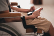 © GAYSORN - Smart handicapped teenager boy on wheelchair is have intention with using mobile phone alone in bedroom for remote or call to parent or friends, Real people's pictures of daily life in the home.