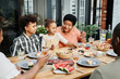© Seventyfour - Portrait of big African-American family enjoying dinner together outdoors and smiling happily
