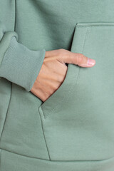 Wall Mural - Woman in green hoodie. Comfortable pocket close up. Warm clothing for autumn or winter