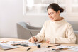 © Pixel-Shot - Female Asian calligraphist working in office