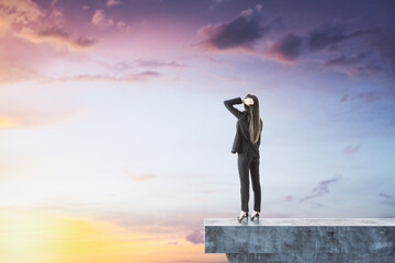 Wall Mural - Female on abstract concrete edge looking into the distance on creative bright sky background with mock up place. Future, tomorrow and success concept.